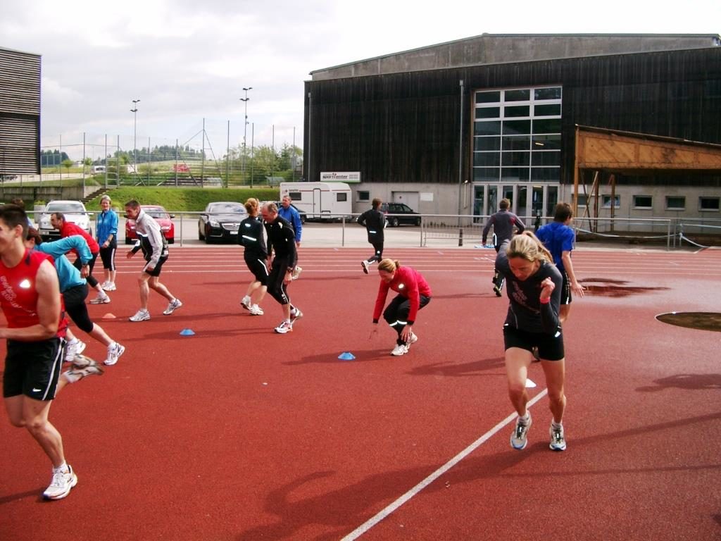 Teilnehmende eines Ausbildungskurse absolvieren Übungen auf einer Leichtathletik-Anlage