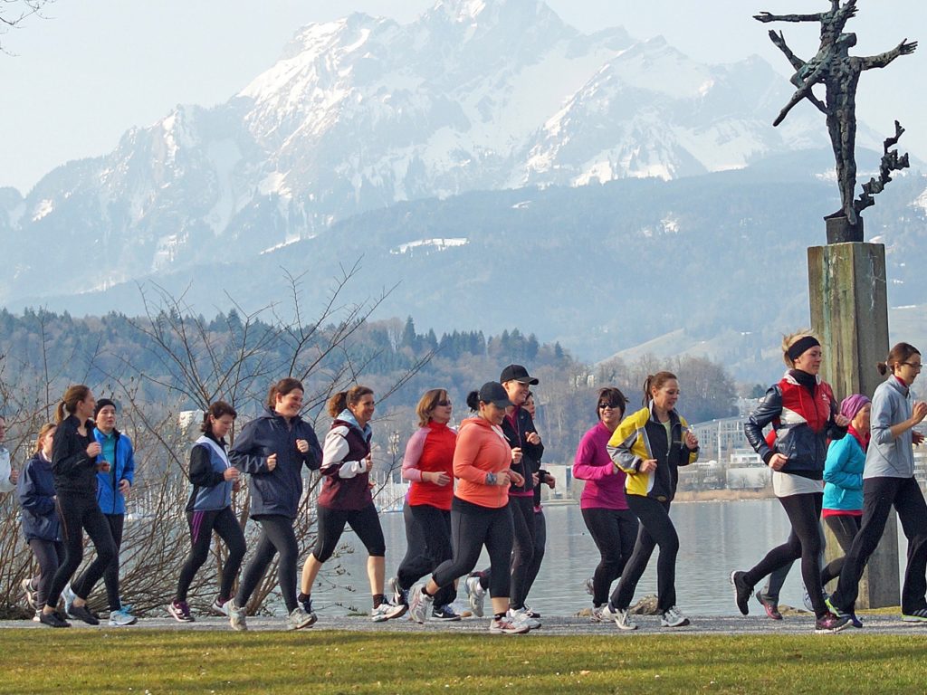 Eine Gruppe von Frauen trainiert zusammen laufend am Vierwaldstädtersee